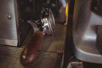 Primer plano del portafilter en la máquina de café expreso en la cafetería - foto de stock