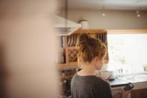 Donna che utilizza il telefono cellulare in cucina a casa — Foto stock