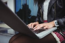 Середина жінки, використовуючи ноутбук за межами офісної будівлі — стокове фото
