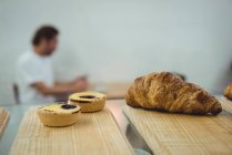 Крупный план печенья и круассана хранится на деревянном столе — стоковое фото