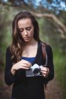 Schöne Frau steht mit Kamera im Wald — Stockfoto