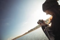 Donna che scatta foto sulla macchina fotografica digitale in una giornata di sole nel parco — Foto stock