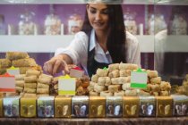 Female shopkeeper arranging turkish sweets at counter in shop — Stock Photo