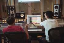 Ingénieurs audio utilisant un mixeur dans un studio d'enregistrement — Photo de stock