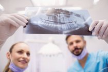 Dentistas discutindo sobre raio-x na clínica odontológica — Fotografia de Stock