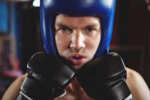 Boxer in casco eseguire posizione di pugilato in sala fitness — Foto stock