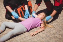 Sanitäter untersuchen verletztes Mädchen auf Straße — Stockfoto