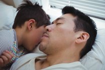 Père et fils dorment ensemble dans la chambre à coucher à la maison — Photo de stock