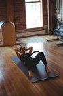 Frau übt Pilates auf Gymnastikmatte im Fitnessstudio — Stockfoto