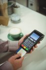 Gros plan des mains effectuant le paiement par carte de crédit dans le café — Photo de stock