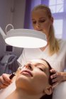Female dermatologist performing laser hair removal on patient face in clinic — Stock Photo