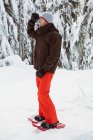 Esquiador de pie y mirando a una distancia en el paisaje cubierto de nieve - foto de stock
