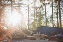 Bauarbeiter verlädt Holz auf Planierraupe auf Baustelle — Stockfoto
