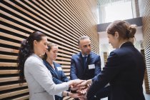 Business people stacking hands together in office — Stock Photo