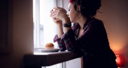 Задумчивая женщина выпивает чашку кофе в кафе — стоковое фото