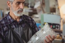 Glassblower examining glassware at glassblowing factory — Stock Photo