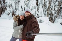 Щаслива пара лижників приймає селфі на засніженій горі — стокове фото