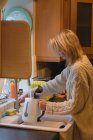 Женщина стирает банку на кухне дома — стоковое фото