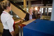 Empresaria en cola recibiendo pasaporte y tarjeta de embarque en la terminal del aeropuerto - foto de stock