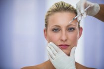 Nahaufnahme einer Patientin, die Botox auf die Stirn gespritzt bekommt — Stockfoto