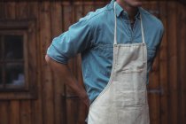 Mid section of man wearing apron at home brewery — Stock Photo