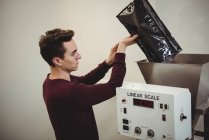 Homme versant des grains de café dans la machine de pesage dans le café — Photo de stock