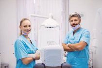 Retrato de dentistas de pé com os braços cruzados na clínica odontológica — Fotografia de Stock