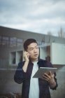 Business executive parlare sul cellulare durante l'utilizzo di tablet digitale in ufficio — Foto stock