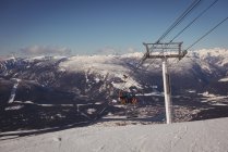 Низкий угол обзора лыжников, путешествующих на подъемнике на горнолыжном курорте — стоковое фото