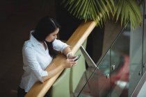 Geschäftsfrau benutzt Handy auf Bürobalkon — Stockfoto