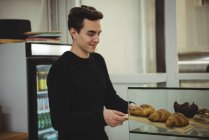 Uomo rimuovere il vassoio di croissant in caffetteria — Foto stock