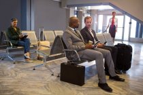 Empresario que interactúa en la sala de espera en el aeropuerto - foto de stock