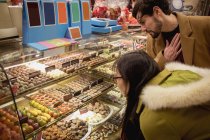 Couple looking at desserts at dessert counter in the supermarket — Stock Photo