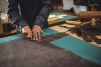 Meados de seção de artesã cortando couro na oficina — Fotografia de Stock