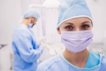 Portrait of female dentist wearing surgical mask in clinic — Stock Photo