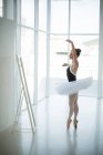 Bailarina praticando dança de balé na frente do espelho no estúdio — Fotografia de Stock