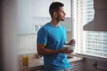 Homem tomando café da manhã na cozinha em casa — Fotografia de Stock