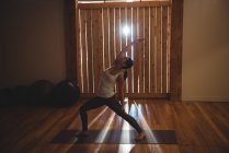 Жінка практикує йогу в фітнес-студії з підсвічуванням — стокове фото