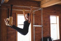 Determined woman practicing pilates in fitness studio equipment — Stock Photo