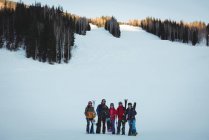 Group of skiers with skies standing on snowy landscape in ski resort — Stock Photo