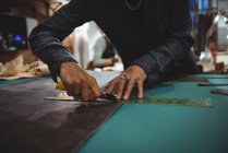 Sección media de la artesana de corte de cuero en el taller - foto de stock
