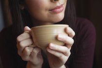 Удумлива жінка має чашку кави в кафе — стокове фото