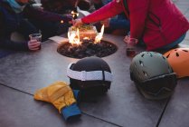 Group of skiers sitting at fire place in ski resort — Stock Photo
