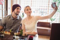 Пара беручи selfie маючи суші у ресторані — стокове фото