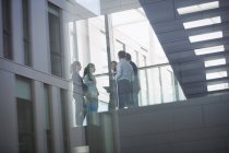 Gruppe von Geschäftsleuten interagiert im Flur eines Bürogebäudes — Stockfoto