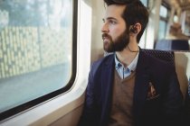 Nachdenklicher Geschäftsmann blickt durch Zugfenster — Stockfoto