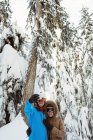 Feliz pareja de esquiadores tomando una selfie en el paisaje nevado - foto de stock