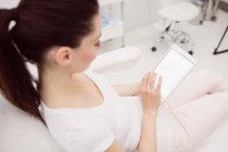 Vista aerea di bella donna che utilizza tablet digitale in sedia clinica — Foto stock