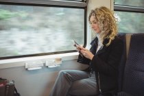 Mulher de negócios focada usando smartphone enquanto viaja — Fotografia de Stock