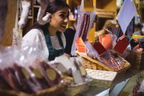 Personale femminile sorridente al bancone della carne al supermercato — Foto stock